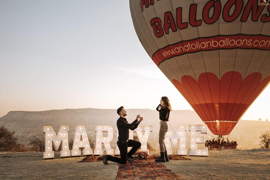 Marriage Proposal Surprise & Engagement in Cappadocia - The yes moment: balloons in the background, champagne style after